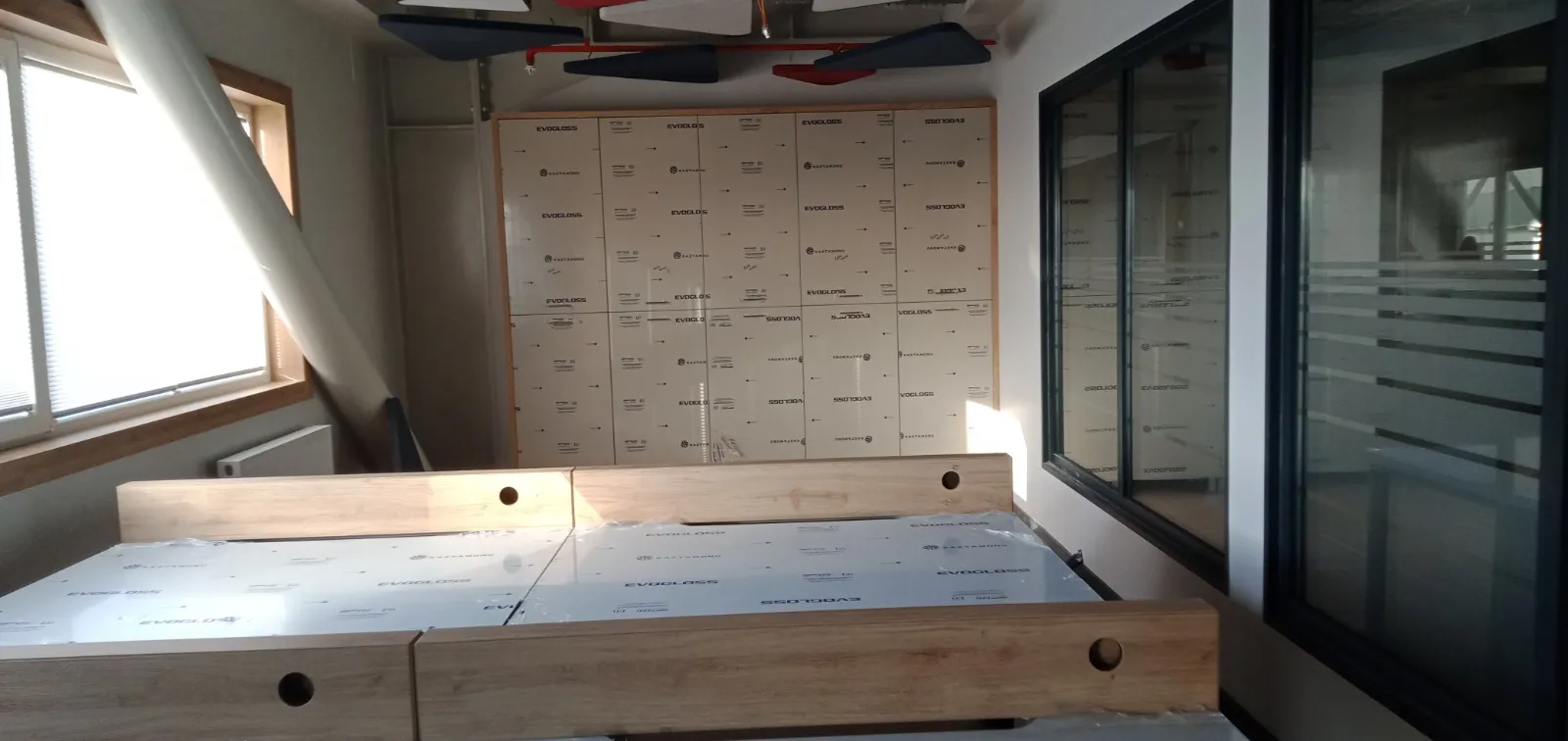 Açık ofiste boy dolap bloğu ve kurulum bekleyen çalışma masası tablaları