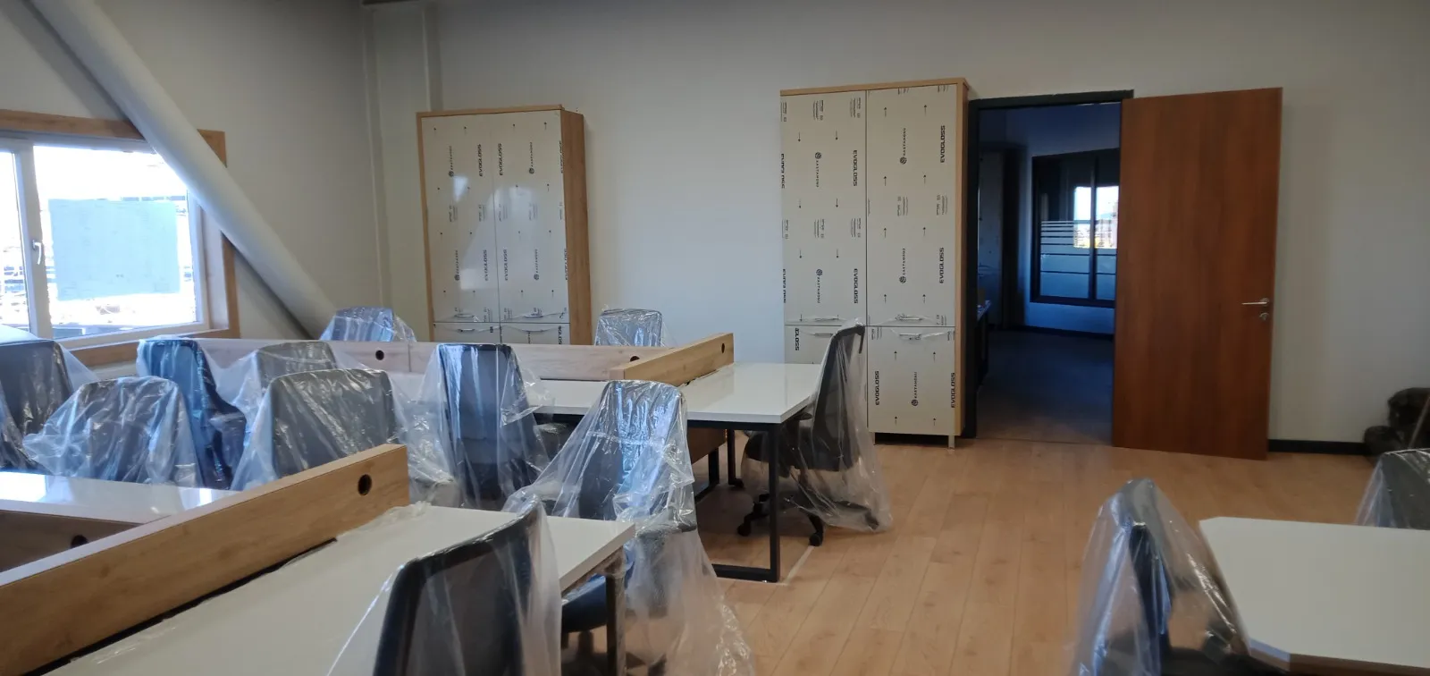 Açık ofiste sıralı çalışma masaları ve boy dolap blokları
