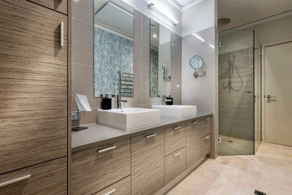 Ahşap desenli çift lavabolu banyo dolabı, gri tezgah ve camlı köşe duş kabini